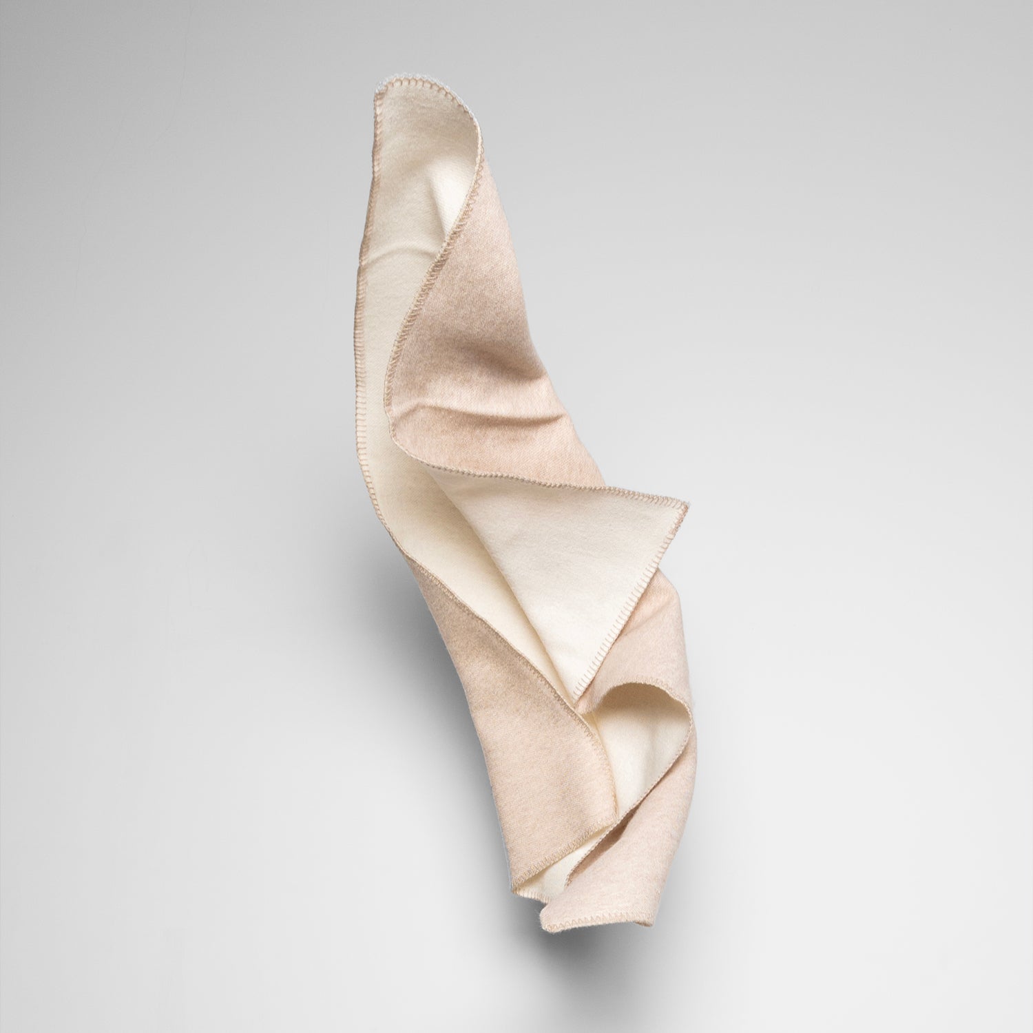 Elegant beige och vit merinoullfilt från Skogen Baby, mjuk och lyxig för både bebisar och vuxna.